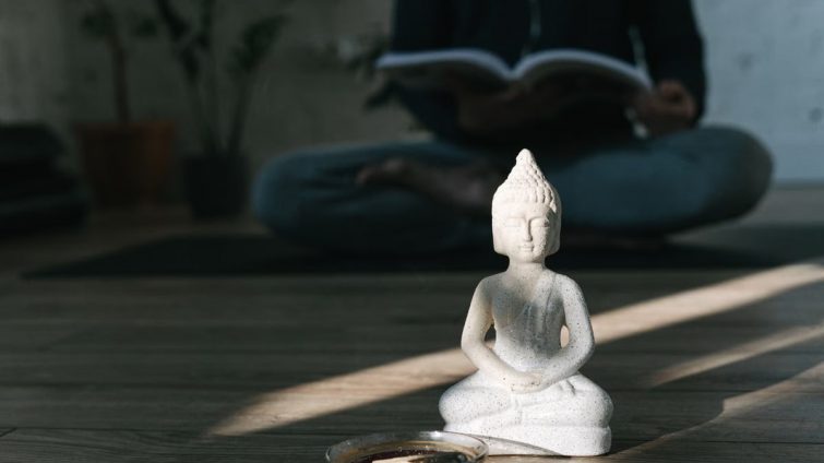 A serene scene featuring a Buddha statue and zen meditation setup, perfect for mindfulness themes.